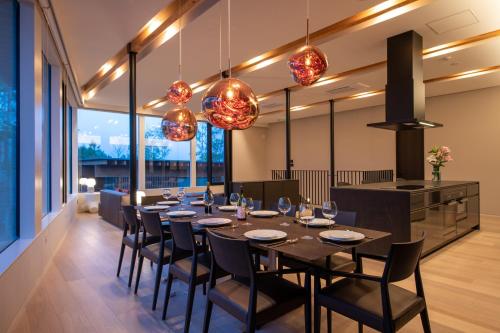 a dining room with a long table and chairs at Yuki Sugi at Intuition in Kutchan
