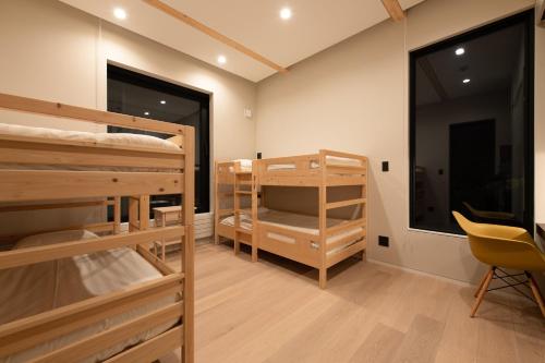 Cette chambre comprend 2 lits superposés et une chaise. dans l'établissement Yuki Sugi at Intuition, à Niseko