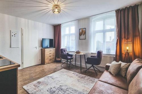 ein Wohnzimmer mit einem Sofa und einem Tisch mit Stühlen in der Unterkunft Hofstelle No1- Erpel in Lübbenau