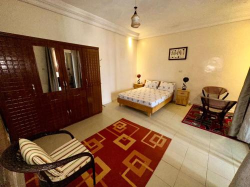 a bedroom with a bed and a couch and a table at Studio Le Virage in Dakar