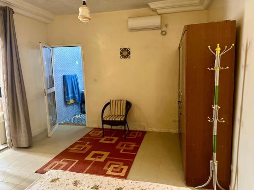 a room with a chair and a door with a window at Studio Le Virage in Dakar