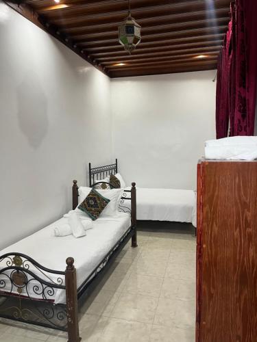 a bedroom with a bed with white sheets at Riad el wazania in Rabat