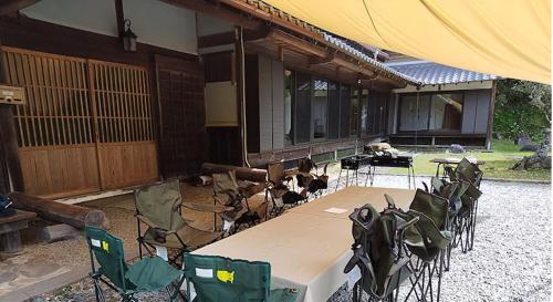 a table and chairs in front of a house at 古民家やまおか in Iwasaki
