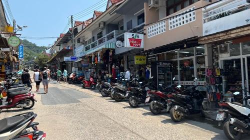 a row of motorcycles parked on the side of a street at Minimal2 MaeHaad in Ko Tao
