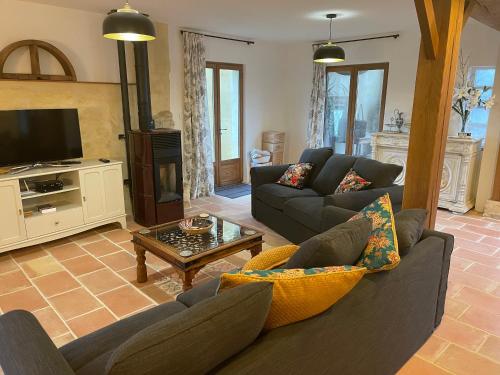 un salon avec deux canapés et une télévision dans l'établissement ChezLeMoulin-Boulangerie, à Samouillan