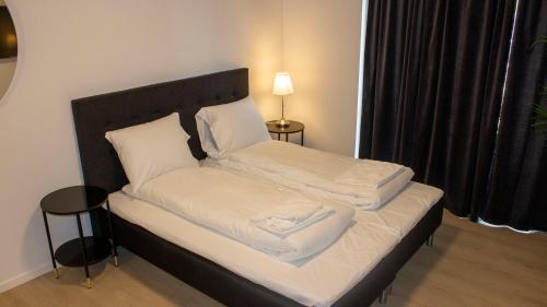 a bed with white sheets and pillows in a room at A Hotels Apartments Høje Taastrup in Tåstrup