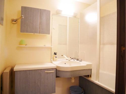 une salle de bain blanche avec un lavabo et un miroir dans l'établissement Le studio de la corniche, à Saint-Hilaire-de-Riez