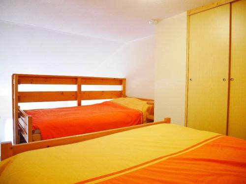 - 2 lits dans une chambre avec des draps orange dans l'établissement Le studio de la corniche, à Saint-Hilaire-de-Riez