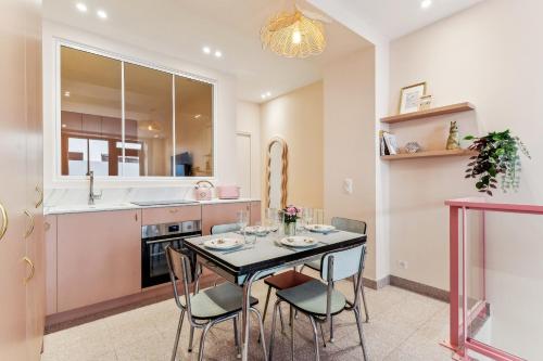 une cuisine et une salle à manger avec une table et des chaises dans l'établissement Appartement élégant -Roquette -6pers, à Paris