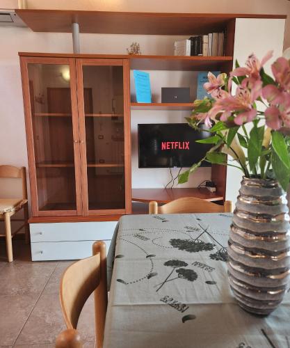 un tavolo con un vaso con dei fiori sopra di Appartamento a due passi dal mare. a Càbras