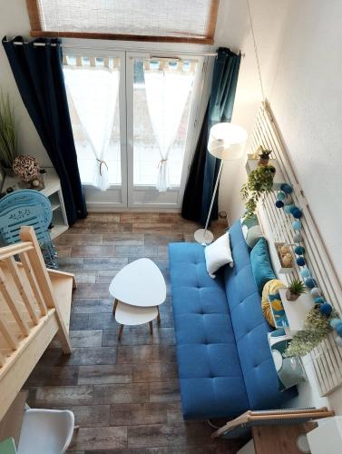 un salon avec un canapé bleu et une table dans l'établissement Le cosy de la corniche d'or, à Saint-Hilaire-de-Riez