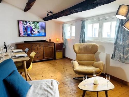 a living room with a couch and chairs and a tv at Le Chaîne - Vieux port centre in La Rochelle