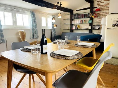 - une table en bois avec des chaises et une bouteille de vin dans l'établissement Le Chaîne - Vieux port centre, à La Rochelle