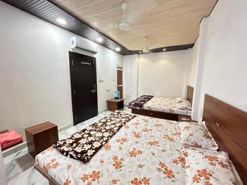 Hotel shree Sidhi vinayak في اوجاين: غرفة نوم بسريرين في غرفة