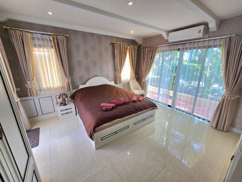 a bedroom with a bed with pink shoes on it at Nusa chivani pool villa najomtien with 4 bedrooms ณุศา ชิวานี พลูวิลล่า 4 ห้องนอน นาจอมเทียน in Na Jomtien