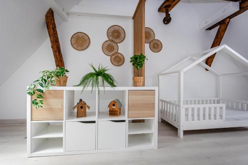 een witte kinderkamer met een wieg en een witte kast bij Le Grenier du Photographe in Kaysersberg