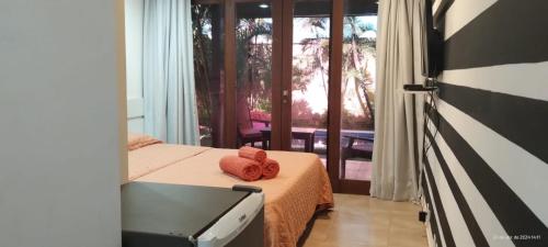 1 dormitorio con 1 cama con 2 toallas en Casa incrivel piscina privada e jacuzzi Villa Deluxe Pipa Spa Beleza Resort, en Pipa