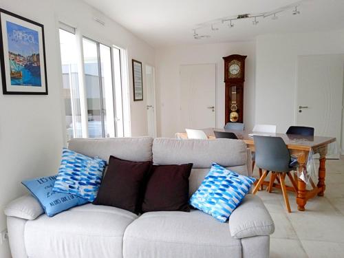 - un salon avec un canapé et des oreillers dans l'établissement La jolie route des Sables, à Saint-Gilles-Croix-de-Vie