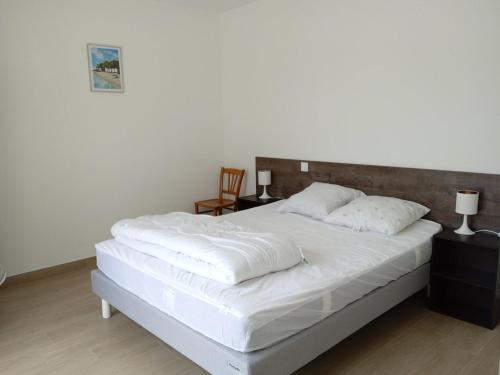 une chambre avec un grand lit avec des draps blancs dans l'établissement La jolie route des Sables, à Saint-Gilles-Croix-de-Vie