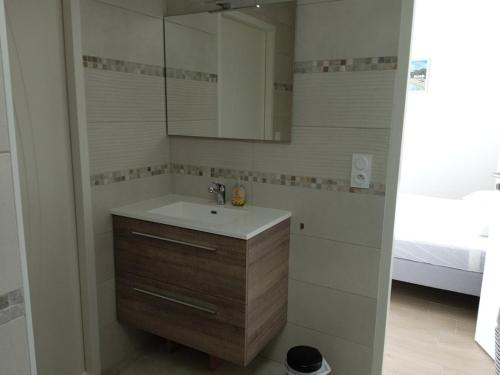 une salle de bain avec un lavabo et un miroir dans l'établissement La jolie route des Sables, à Saint-Gilles-Croix-de-Vie