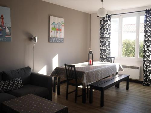 un salon avec une table et un canapé dans l'établissement La croix de Vie du Boisvinet, à Saint-Gilles-Croix-de-Vie