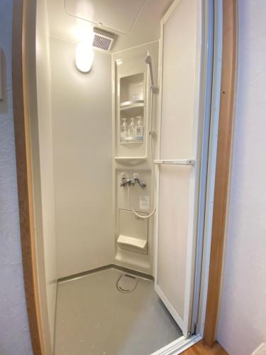a bathroom with a walk in shower with a glass door at Guesthouse Takayama Hanzansha in Takayama