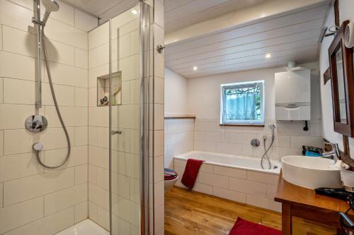 a bathroom with a shower and a tub and a sink at Ferienhaus S' Äckerle in Lauf