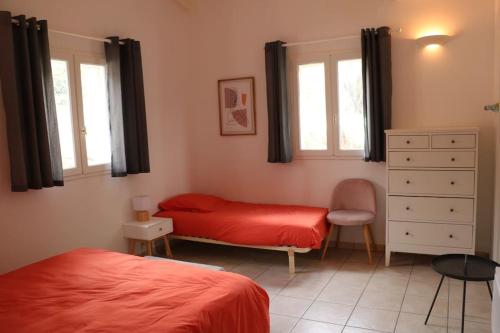 1 Schlafzimmer mit 2 Betten, einer Kommode und 2 Fenstern in der Unterkunft Agréable villa vue mer avec piscine Sagone in Sagone