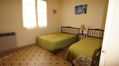 une chambre avec deux lits et une fenêtre dans l'établissement La tranquille de St Hilaire, à Saint-Hilaire-de-Riez