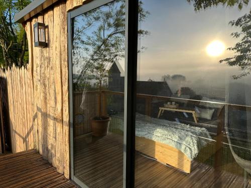 a screened in porch with a bed on a deck at Coeur de Lodge spa privatif in Cramoisy