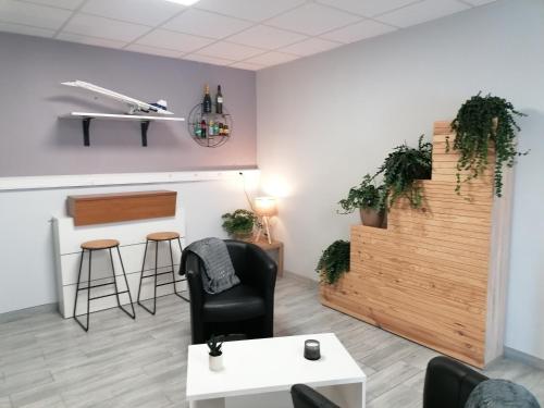 uma sala de estar com uma cadeira preta e uma mesa em Hôtel Némo Aéroport de Pau - KB HOTEL GROUP em Sauvagnon