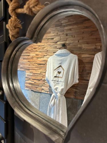a white shirt hanging on a wall in a mirror at Coeur de Lodge spa privatif in Cramoisy