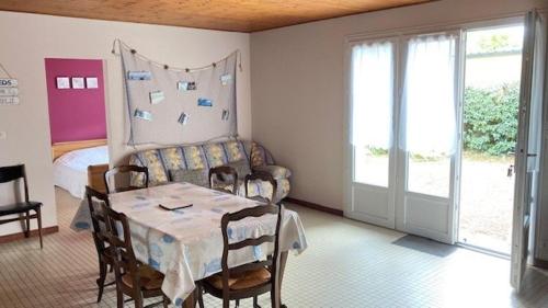 une pièce avec une table, des chaises et un lit dans l'établissement La plage de la Pège, à Saint-Hilaire-de-Riez