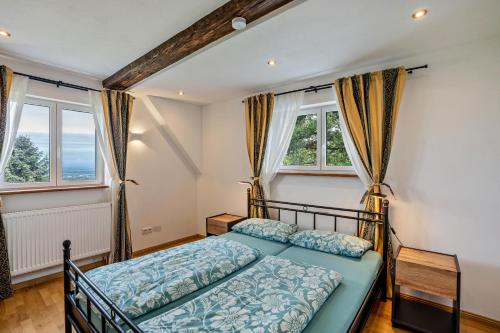 a bedroom with a bed and two windows at Ferienhaus S' Äckerle in Lauf