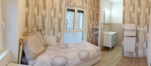 ein kleines Schlafzimmer mit einem Bett und einem Fenster in der Unterkunft Aux nids douillets Mayetois "les hirondelles" in Mayet-de-Montagne