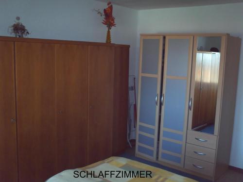 a bedroom with a wooden cabinet and a dresser at REST-ATILA in Hannover