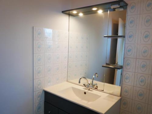 une salle de bain avec un lavabo et un miroir dans l'établissement La plage de la Pège, à Saint-Hilaire-de-Riez