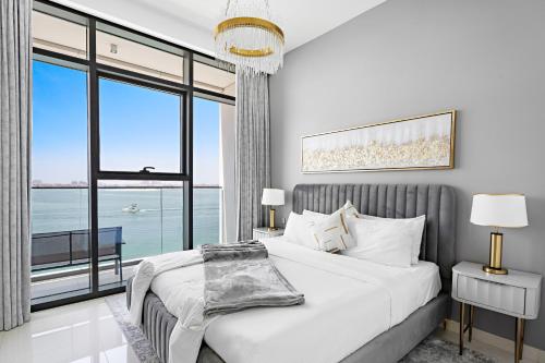Un dormitorio con una cama y una ventana grande. en Seaside Serenity: 1-BR Apartment with Beach Access, en Dubái