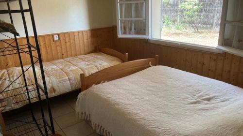 une chambre avec deux lits et une fenêtre dans l'établissement La petite plage de la Pège, à Saint-Hilaire-de-Riez