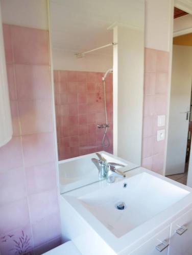 une salle de bain avec un lavabo blanc et une douche dans l'établissement La petite plage de la Pège, à Saint-Hilaire-de-Riez