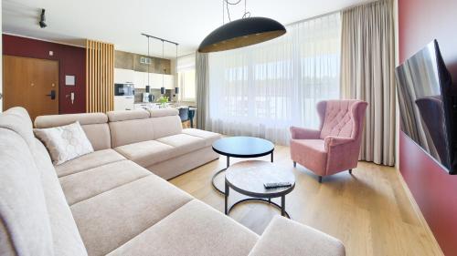 a living room with a white couch and a pink chair at Międzyzdroje Aquamarina, Sun & Snow in Międzyzdroje