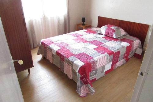 Schlafzimmer mit einem Bett mit einer roten und weißen Decke in der Unterkunft Pétrouchka dans les pins in Saint-Hilaire-de-Riez