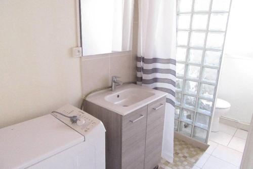 La salle de bains blanche est pourvue d'un lavabo et d'une fenêtre. dans l'établissement Pétrouchka dans les pins, à Saint-Hilaire-de-Riez
