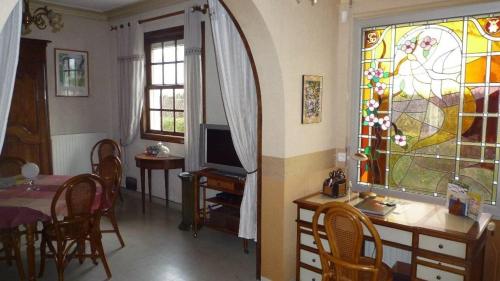un salon avec une table et un vitrail dans l'établissement La Villa de la foret, à Saint-Hilaire-de-Riez