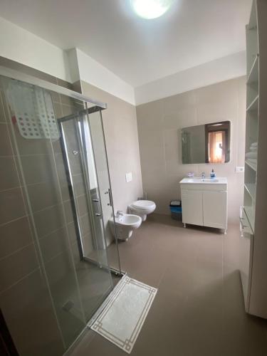 um banheiro com chuveiro, vaso sanitário e pia em Villa with private pool em Durrës