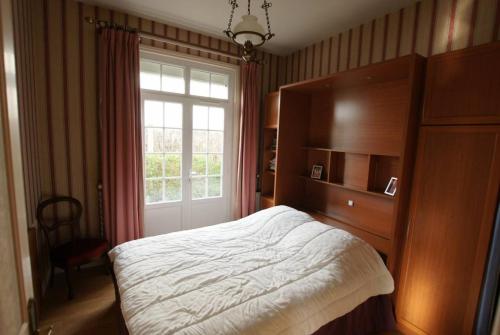 une chambre avec un grand lit et une fenêtre dans l'établissement La Villa de la foret, à Saint-Hilaire-de-Riez