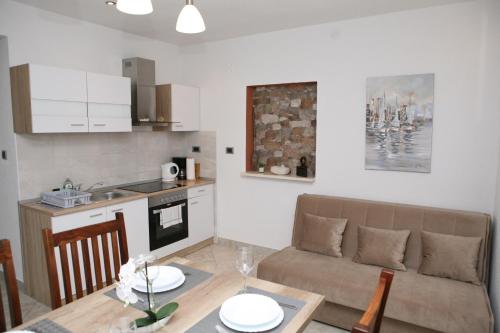 cocina y sala de estar con sofá y mesa en Apartments Old Town, en Trogir