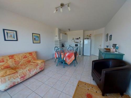 un salon avec un canapé et une cuisine dans l'établissement La baie de Sion, à Saint-Hilaire-de-Riez