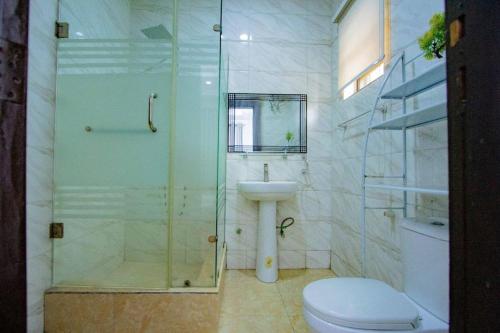 a bathroom with a shower and a toilet and a sink at Treasurablehomes in Maiyegun