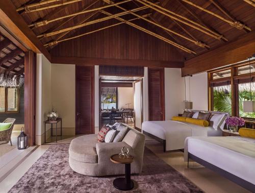 a living room with two beds and a couch at One&Only Reethi Rah in Reethi Rah